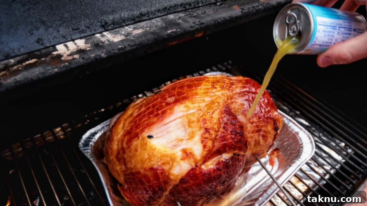 Sweet Apricot Smoked Ham 5 Pineapple juice being poured from a can over a spiral ham resting in an aluminum pan on a smoker.