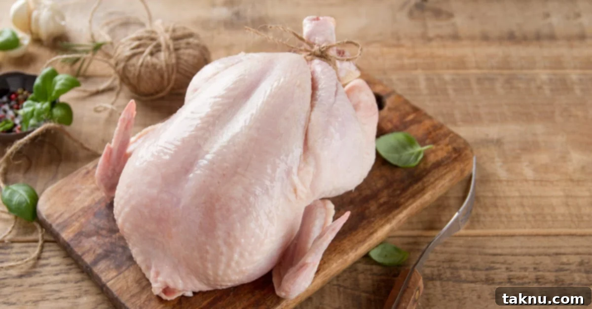 Traeger Smoked Buttermilk Chicken 3 Whole chicken on wooden table with legs tied together, ready for cooking.