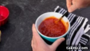 Pineapple glaze in white dish with a spoon, ready to be applied.