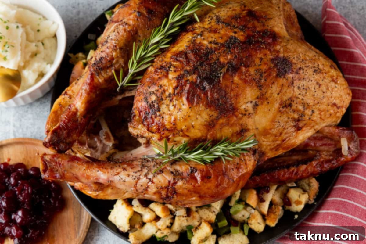 Smoked traeger turkey on black platter with stuffing and potatoes.