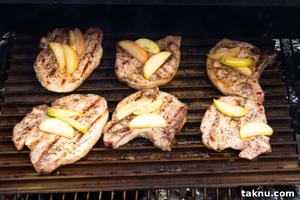 Smoky Pork Chops with Sweet Apple Glaze 8 Sizzling pork chops adorned with sweet apple slices, searing on a high-heat grill rack, creating a delicious crust.