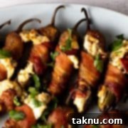 Sizzling Christmas BBQ Recipes 11 Cooked cream cheese stuffed bacon wrapped jalapenos on white plate.