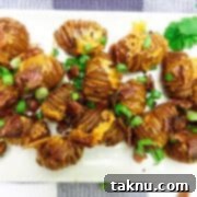 Sizzling Christmas BBQ Recipes 13 Hasselback potatoes on white dish with bacon and green onions on top