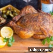 Sizzling Christmas BBQ Recipes 9 Smoked whole chicken on cutting board with lemons. Potatoes and brussel sprouts in background.