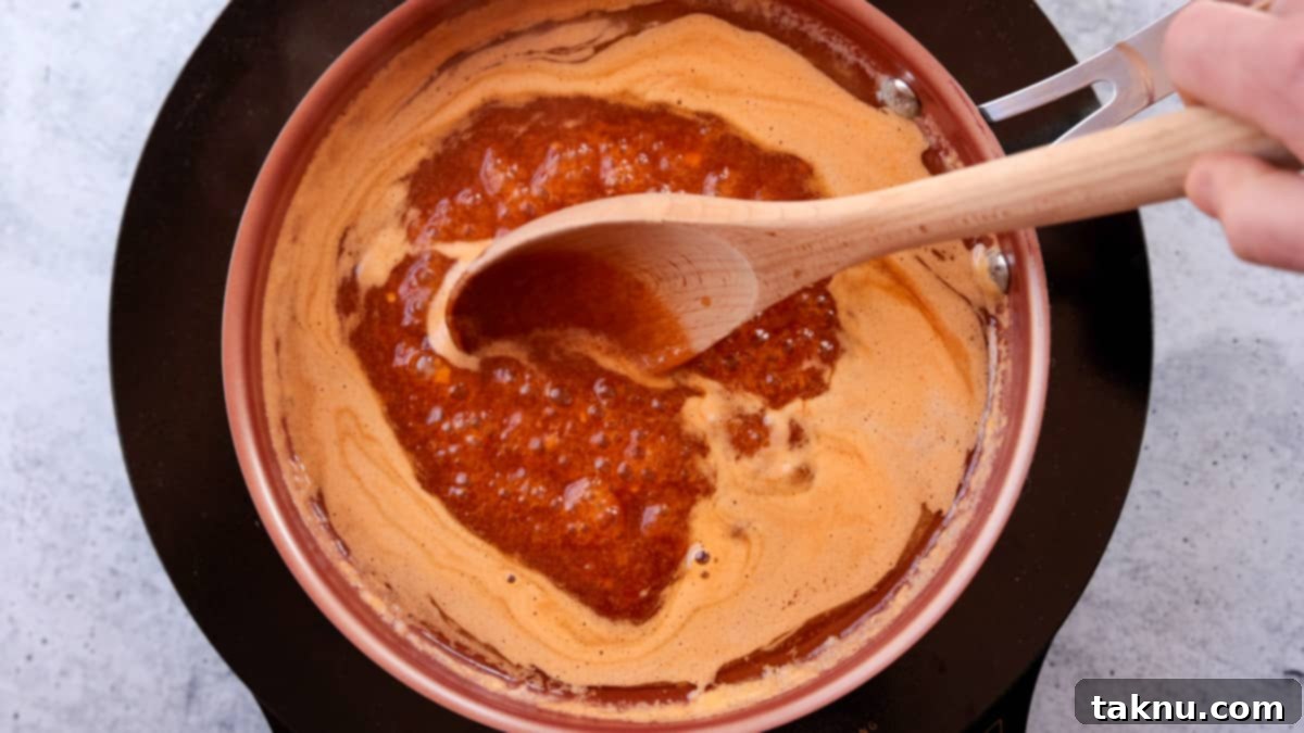 Fiery Sriracha Smoked Spatchcock Turkey 6 Sriracha honey glaze heated in copper pan and being stirred with a wooden spoon.