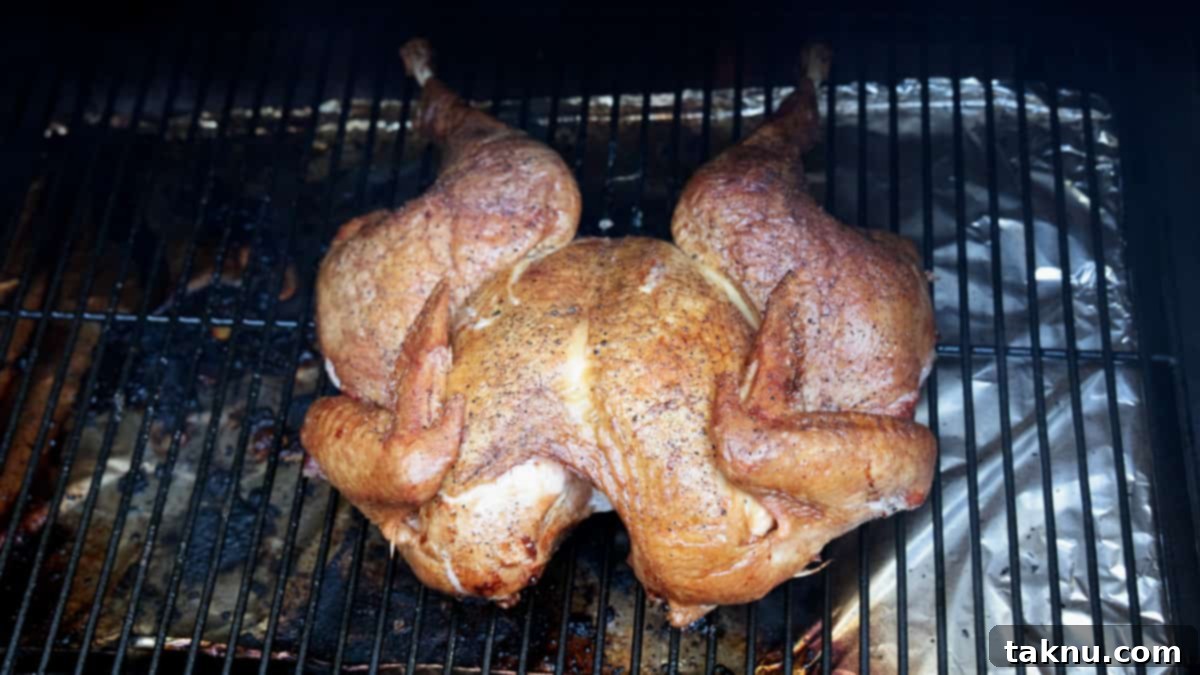 Fiery Sriracha Smoked Spatchcock Turkey 7 Turkey being cooked on smoker laying directly on grill grates.