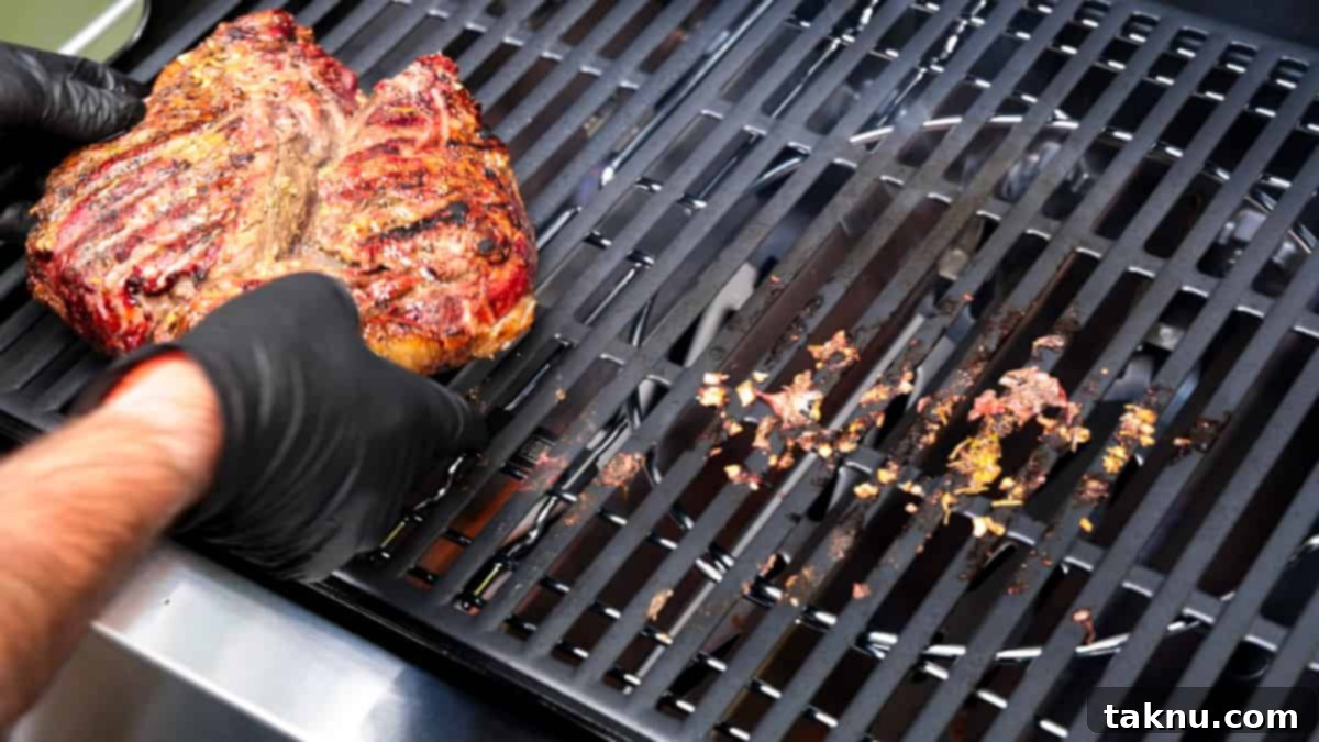 Lamb roast seared on hot grill. Flipping by hand while wearing black gloves.