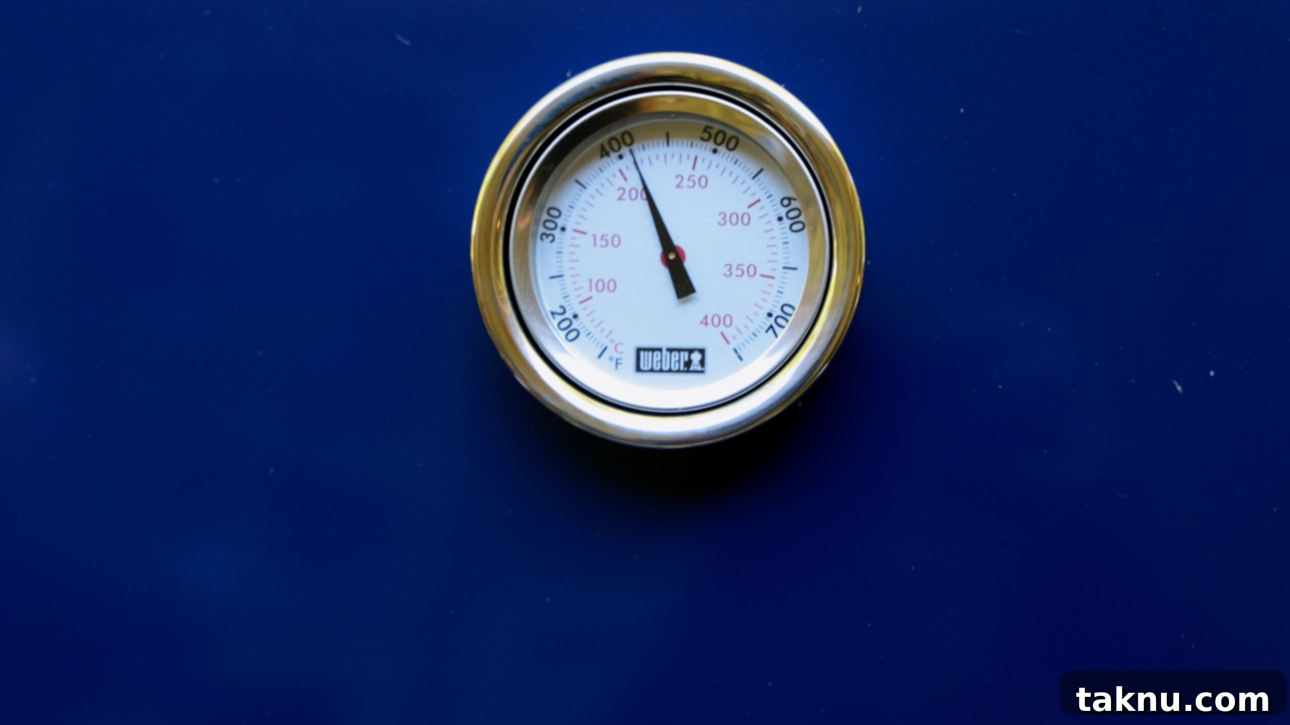 A blue gas grill with the thermometer showing 400 degrees Fahrenheit, indicating it's preheated and ready.