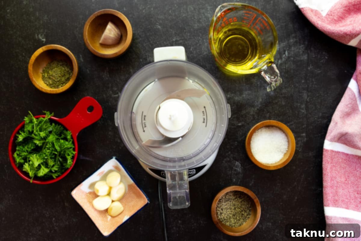 Food processor with small dishes of finely chopped garlic, fresh parsley, sliced shallot, and small bowls of salt, pepper, & olive oil, all prepared for blending into the marinade.