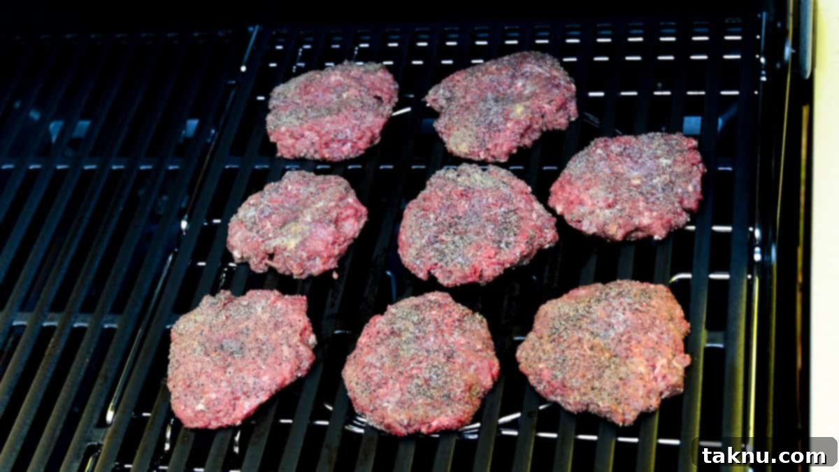 Bison burger patties on grill starting to cook.