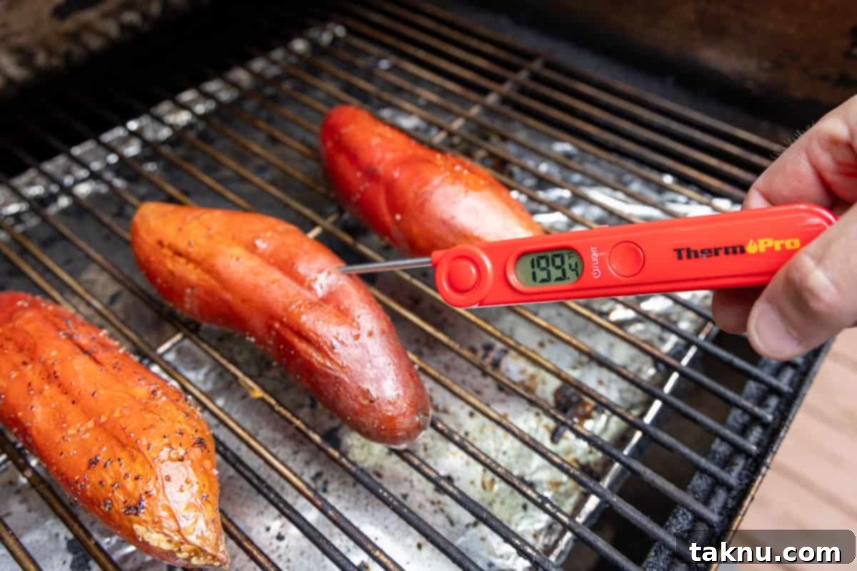 Checking internal temperature of grilled potatoes with thermometer.