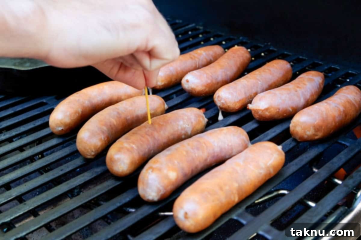 Savory Sausage and Roasted Peppers 6 Poking holes in sausages on grill with a toothpick.