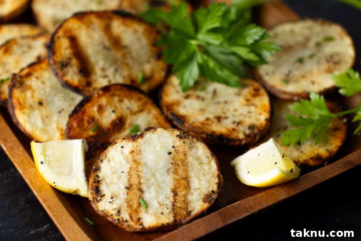 A dozen thinly sliced grilled potatoes on wooden serving platter garnished with parsley and lemon slices.