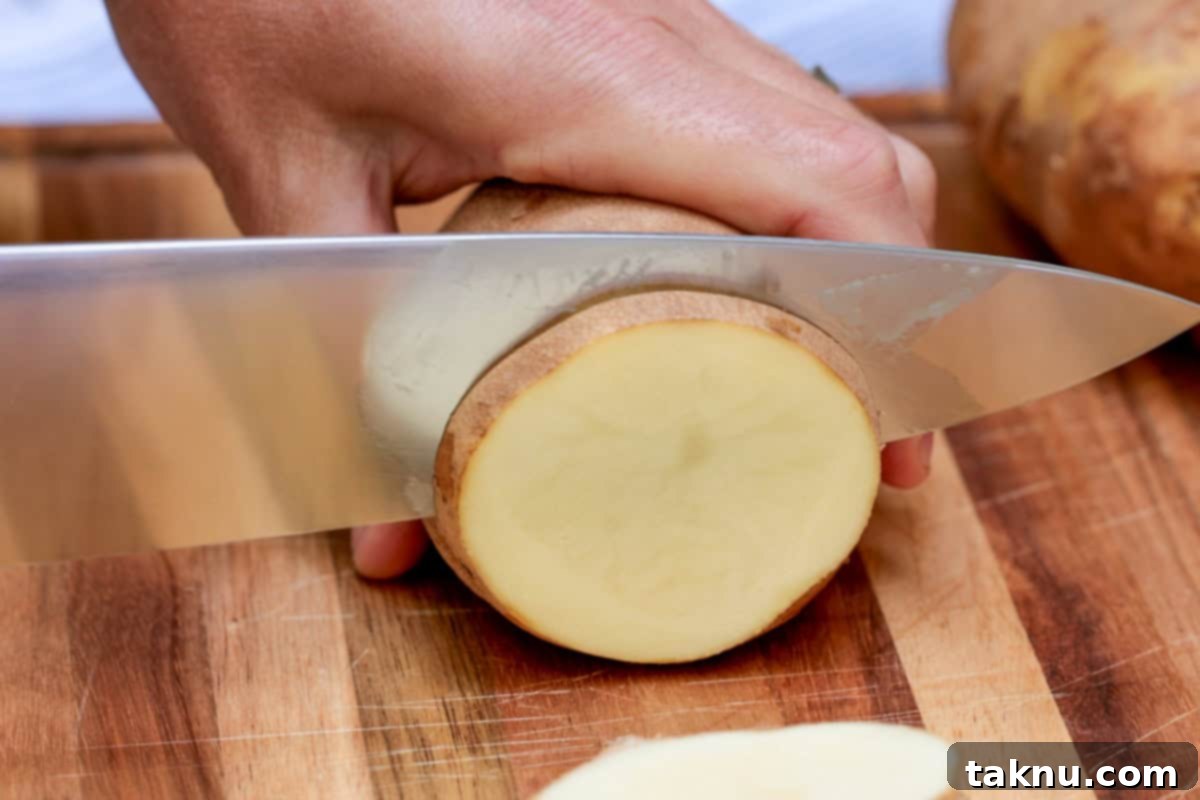 Slicing a russet potato with a large chef\