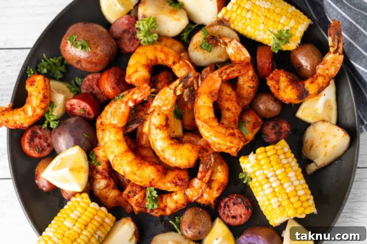 Succulent Smoked Shrimp 11 A dozen beautifully smoked shrimp arranged on a black platter, garnished with fresh corn, tender potatoes, and vibrant lemon slices, ready to be served.