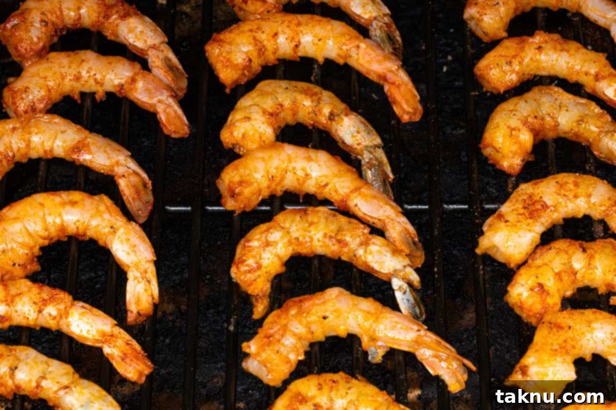 Succulent Smoked Shrimp 9 Neatly arranged rows of seasoned shrimp cooking directly on the grill grates inside a smoker, absorbing flavorful smoke.