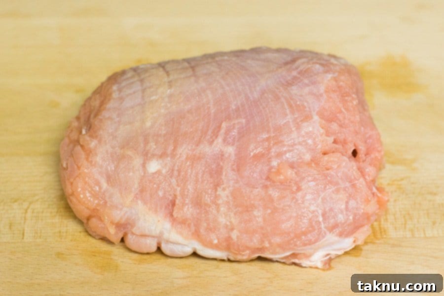 A trimmed, raw turkey breast, ready to be expertly sliced into thin strips for crafting delicious homemade jerky.