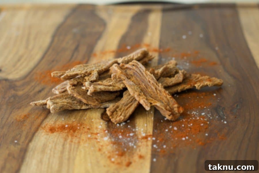 A generous pile of freshly made Smokey Cajun turkey jerky, perfectly dried, showcasing its delicious texture and inviting appearance, ready for snacking.