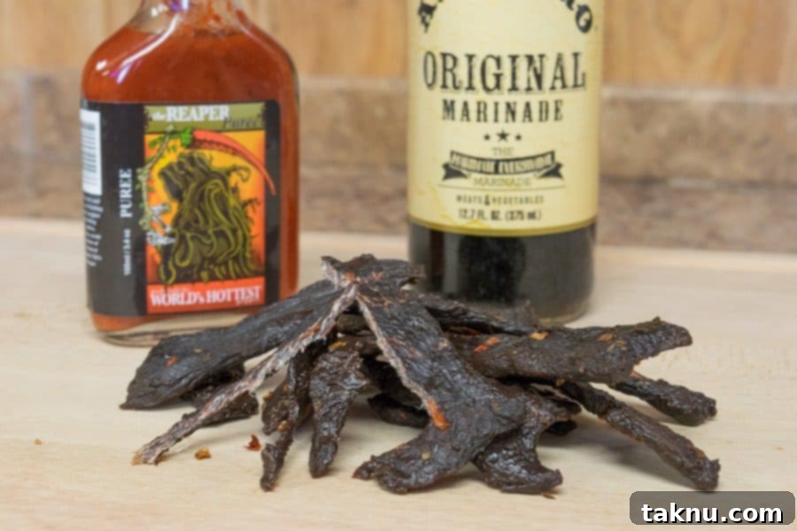 Reaper's Harvest Elk Jerky 8 Close-up of Grim Reaper Elk Jerky with fresh Carolina Reaper peppers for context