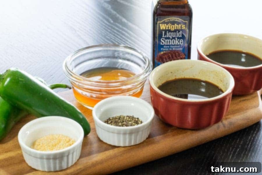 Fresh ingredients for a spicy jalapeño beef jerky marinade, including whole and sliced jalapeños, on a rustic cutting board