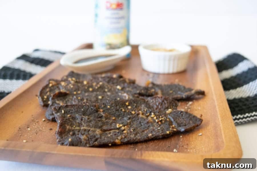 Freshly made beef jerky strips arranged on a wooden cutting board