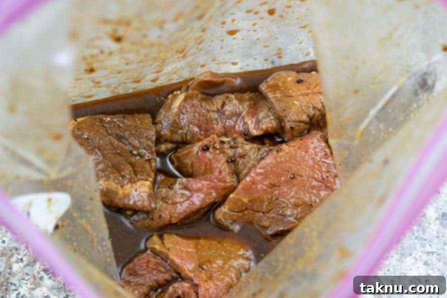 Beef top round strips marinating in a clear ziplock bag