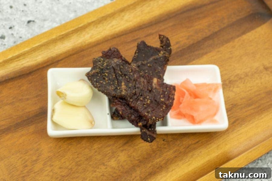 Kikkoman Glazed Teriyaki Beef Jerky 14 Teriyaki jerky on tray with garlic