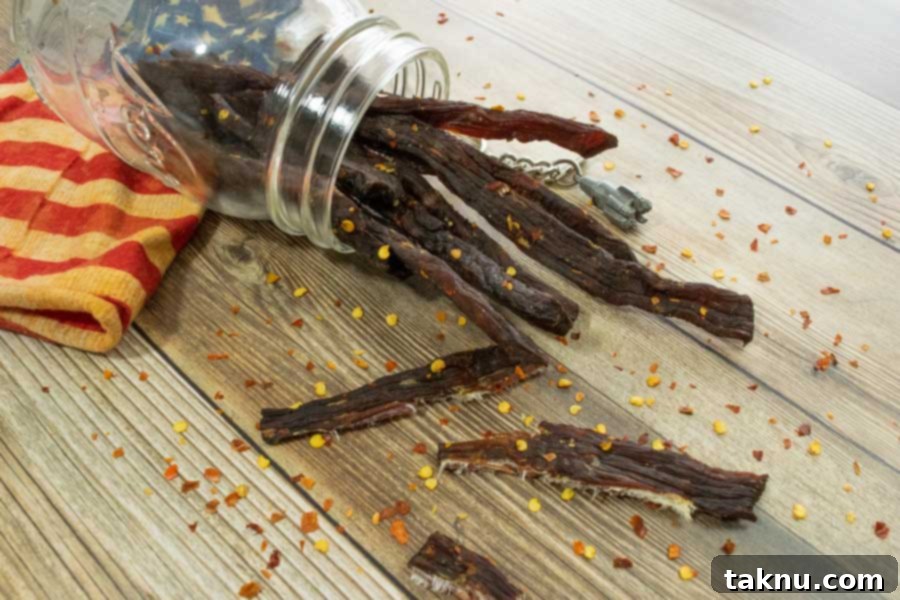 Roughneck Jerky 10 Jerky in jar with red pepper flakes on wood