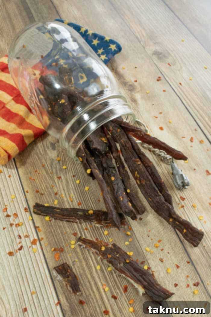 Roughneck Jerky 8 Jerky in a jar laying on wood with red pepper flakes and american flag