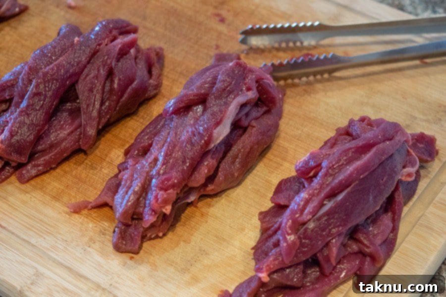 Twisted Venison Jerky 7 Venison sliced for jerky on cutting board with tongs