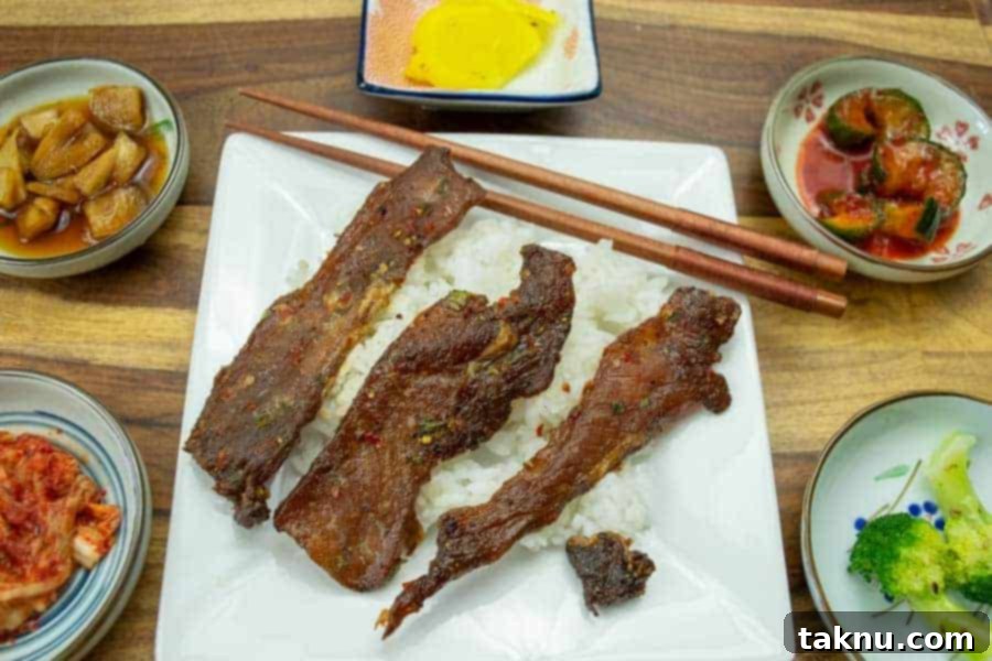 Pork jerky atop rice with korean small plates around