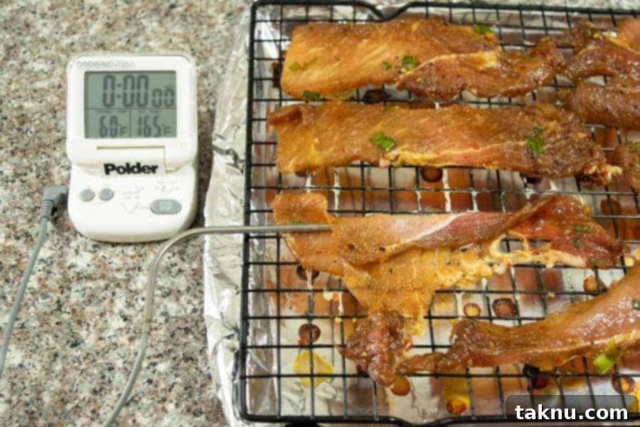 korean bbq pork jerky on oven tray with thermometer