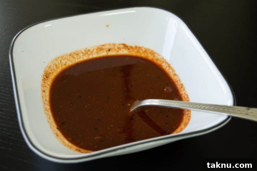 The vibrant Habanero Tabasco beef jerky marinade expertly mixed in a bowl, showcasing its rich, deep color.