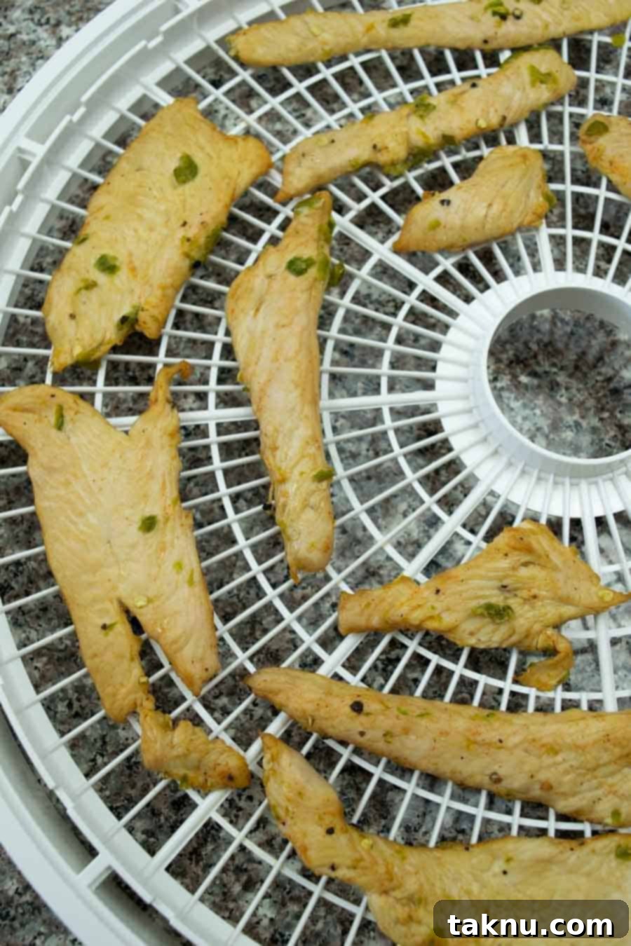 turkey jerky on dehydrator trays ready to dry