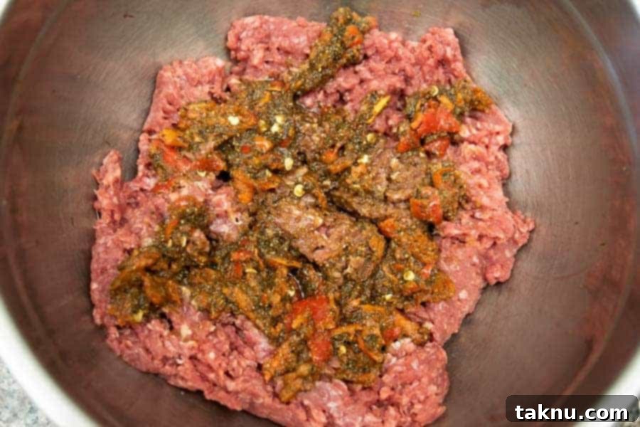 spicy ingredients on top of ground beef for jerky