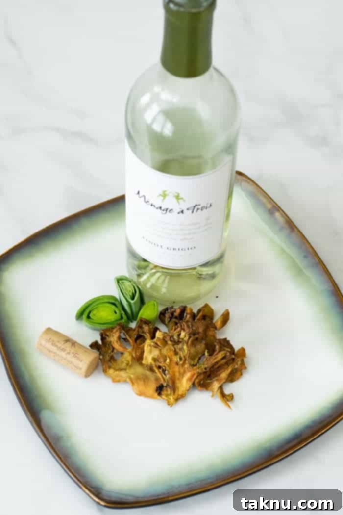 Umami Mushroom Jerky 12 Close-up of finished Maitake mushroom jerky pieces on a plate, with a wine bottle and cork in the background, emphasizing the gourmet presentation.