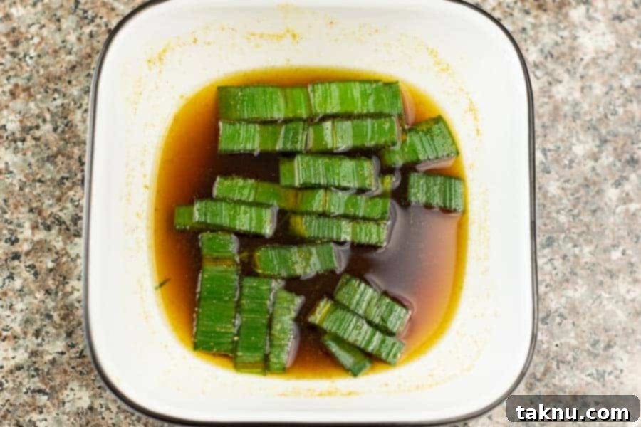 Umami Mushroom Jerky 5 A vibrant, thick jerky marinade with finely chopped leeks, showcasing its rich texture and color in a white bowl, ready to be blended.