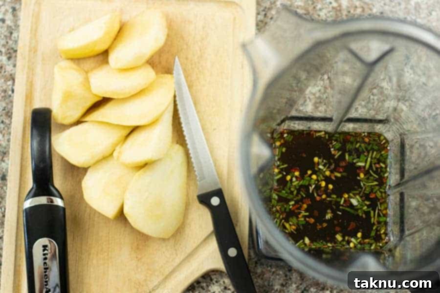 sliced rosemary on cutting board with blender next to it with liquid ingredients