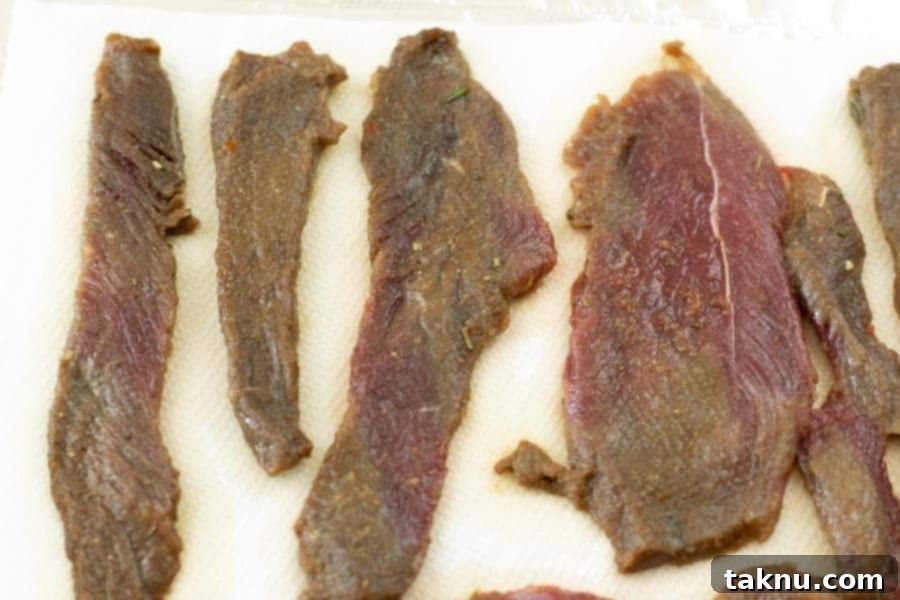 Venison jerky drying on paper towels