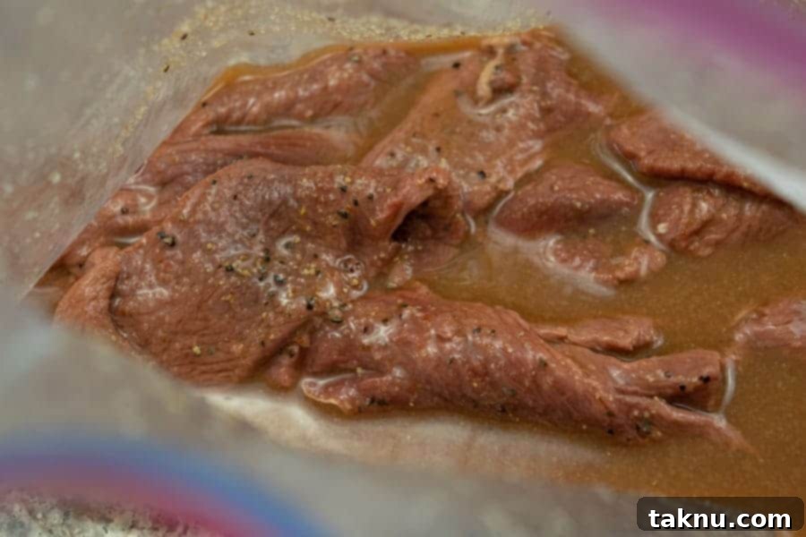 Sriracha deer jerky marinating in a ziplock bag, absorbing full flavors