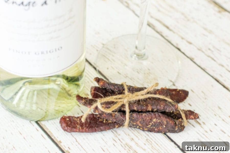 Vintner's Mash Beef Jerky 11 Finished white wine beef jerky next to a bottle of wine, tied with twine