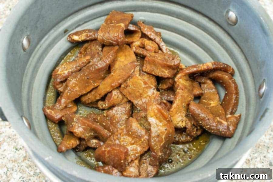 Vintner's Mash Beef Jerky 8 Beef jerky strips straining in a colander to remove excess marinade