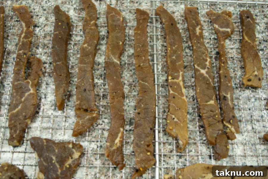 Lemon pepper jerky on dehydrator trays ready to dry
