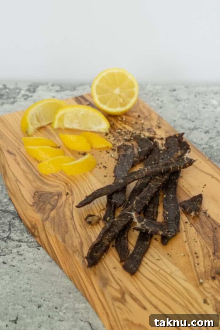 Lemon Pepper Beef jerky on cutting board with lemons