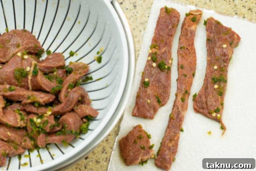 Blaze Beef Jerky 13 Spicy marinated beef jerky strips laid out on paper towels to absorb excess moisture