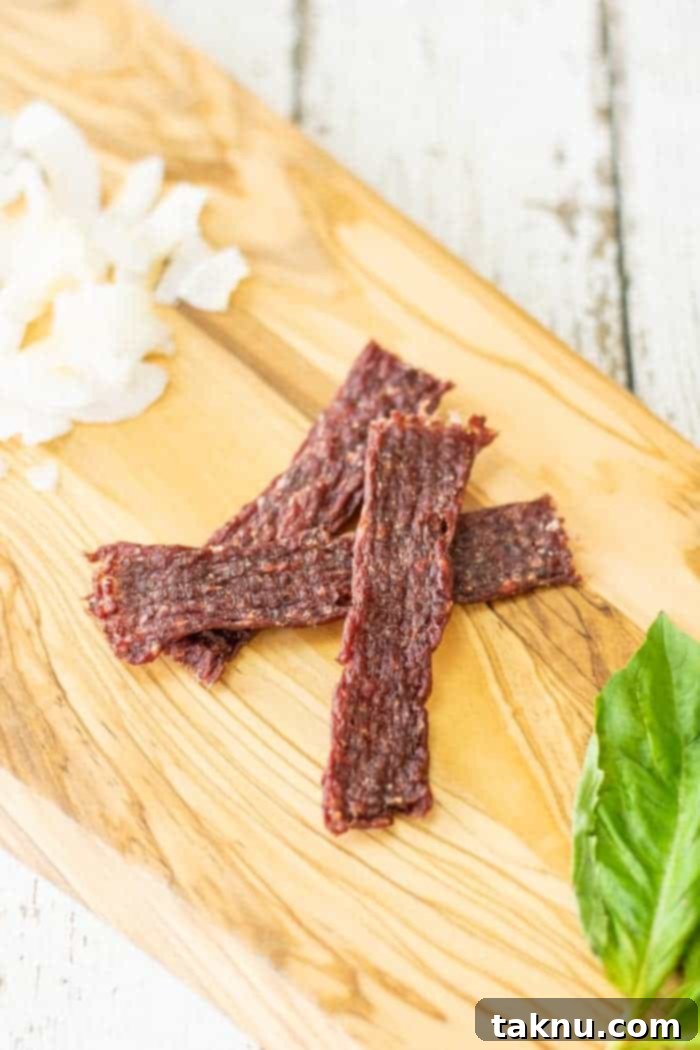 coconut ground jerky on cutting board with coconut shavings and basil