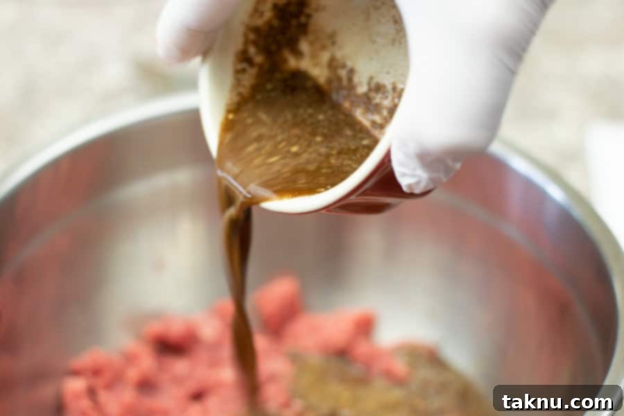 pouring coconut marinade mixture into ground beef