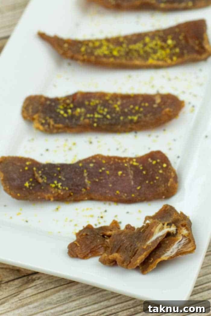 Zesty Inferno Tuna Strips 9 Perfectly dried tuna jerky pieces displayed on a white platter