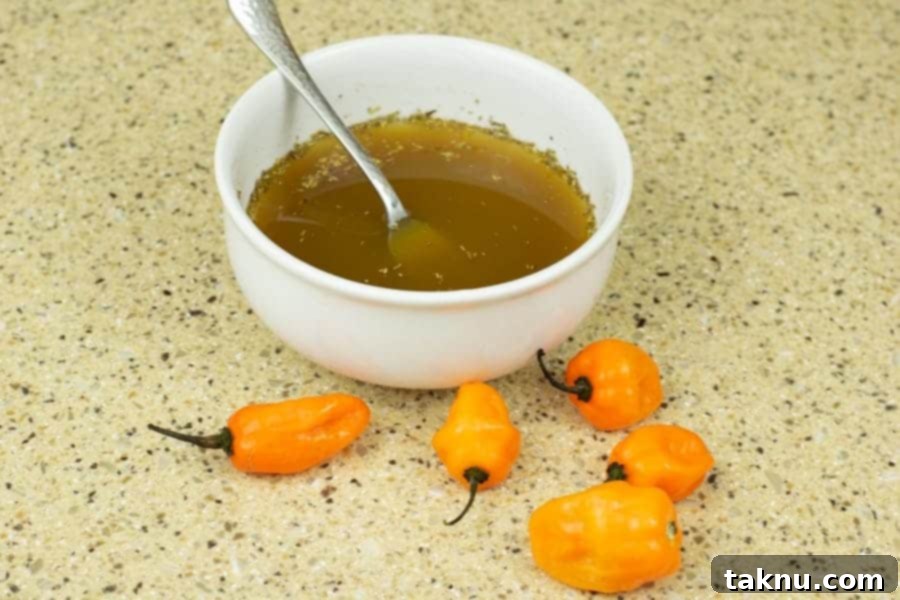Beef jerky marinade in bowl with habaneros around counter