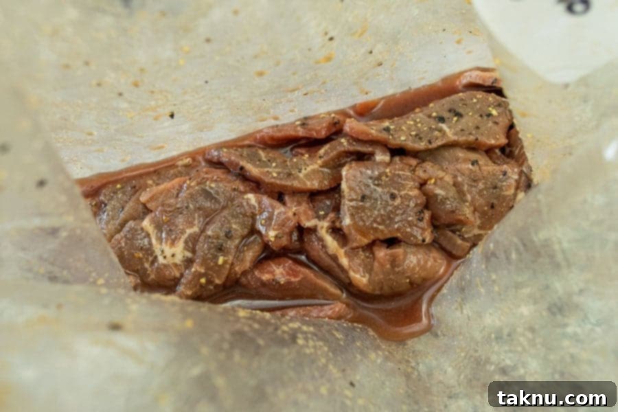 Beef jerky strips marinating in a ziplock bag